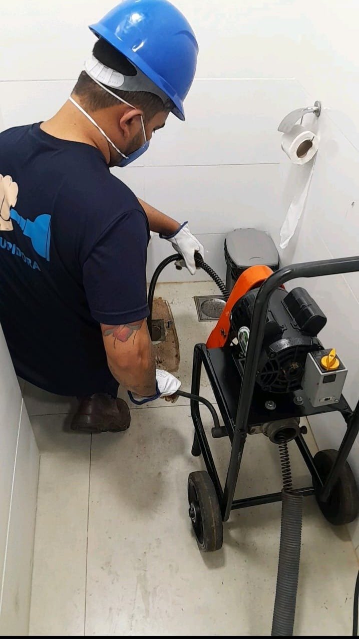 Técnico profissional realizando desentupimento com equipamento moderno
